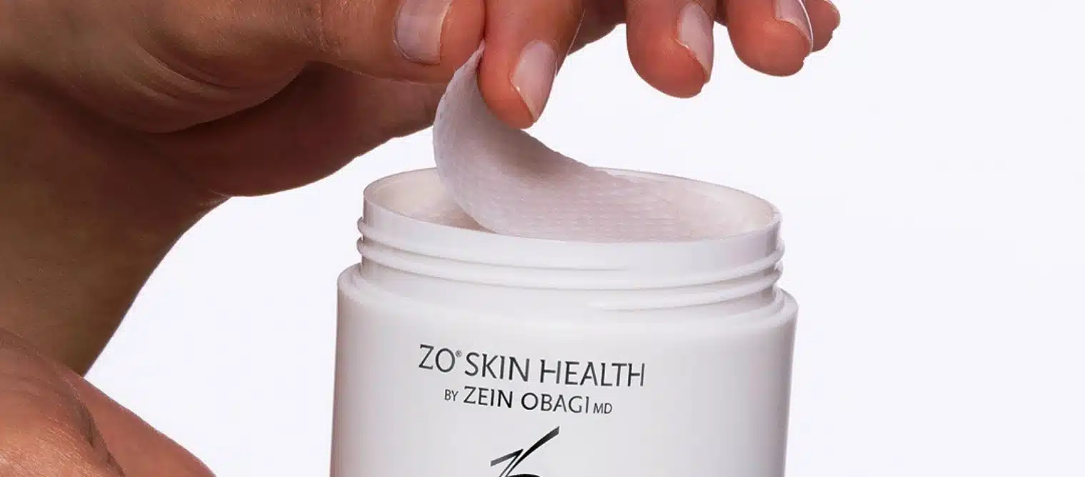 Close-up of one pre-soaked ZO Skin Health Complexion Renewal Pad being lifted from its jar